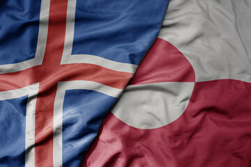 big waving national colorful flag of icelandic and national flag of greenland .
