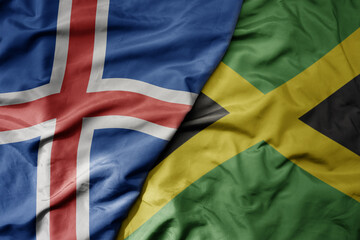 big waving national colorful flag of icelandic and national flag of jamaica .