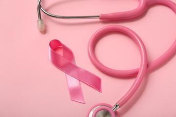 Pink ribbon with stethoscope on color background, closeup. Breast cancer awareness concept