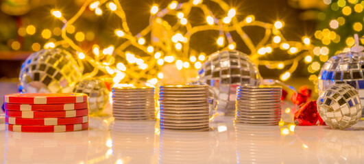 coins and chips against a background of Christmas lights. Christmas background with coins and chips