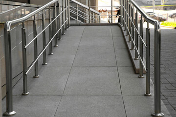 Ramp with metal handrails near building outdoors