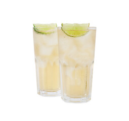 Glasses of tasty ginger ale with ice cubes and lime slices isolated on white