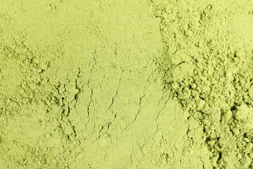 Green matcha powder as background, top view