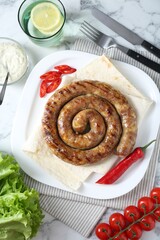 Tasty homemade sausage with chili pepper and lavash served on white marble table, flat lay