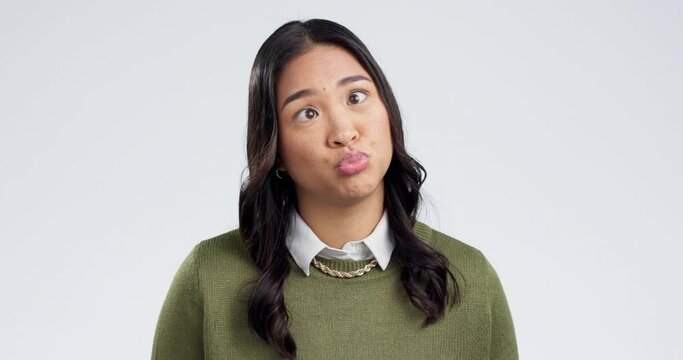 Happy, goofy and face of Asian woman in a studio with funny, comic or funny facial expression. Playful, comedy and portrait of a young female model with silly personality isolated by white background