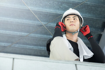 Young male worker wearing a helmet at a construction site Image of steeplejacks and building scaffolding