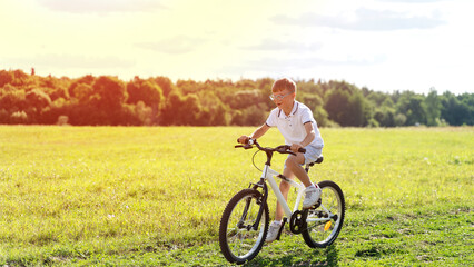 a boy rides a bicycle in nature