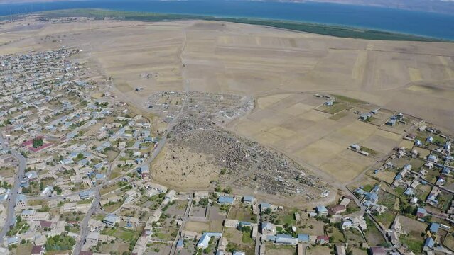 Birds eye view footage of Noratus cemetery, village and Sevan Lake on sunny summer day. Gegharkunik Province, Armenia.