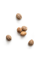 Closeup organic whole raw nutmegs isolated on a white background from above, top view