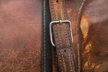 Horse saddle. Detail of the texture, stitching, buckle and leather belt.