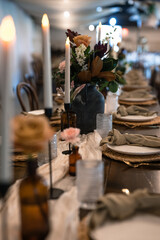 wedding reception table lines with candles, plates and vases of flowers