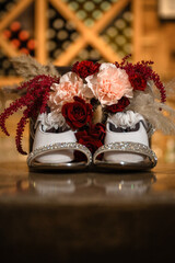 sparkly bridal shoes with bridal bouquet setting on top and flower girl shoes setting inside