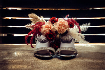 sparkly bridal shoes with bridal bouquet setting on top and flower girl shoes setting inside