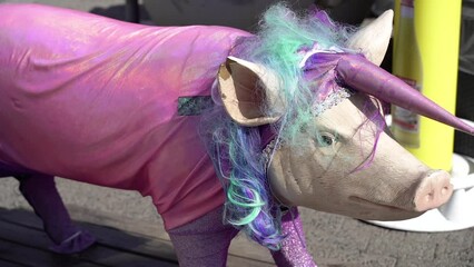 Statue of a pig dressed in a carnival costume of a unicorn.
