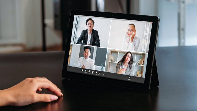 Video telework. Digital office. Diverse men women corporate team tired colleagues discussing business project on tablet screen at modern workplace.