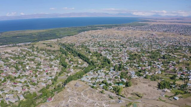 Backward reveal aerial shot of Nerkin Getashen and Martuni on sunny summer day. Gegharkunik Province, Armenia.