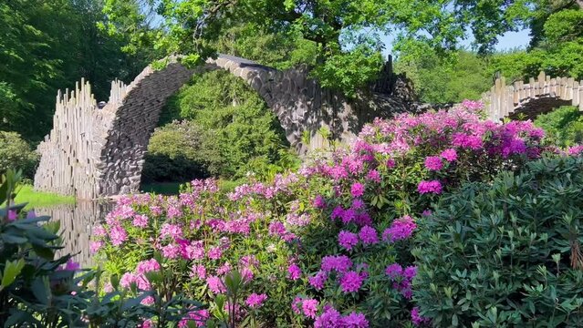 Devil's Bridge Rakotzbrucke in the Rhododendron Palace Landscape Park Kromlau, Lake Rakotz, Saxony, Germany. High quality 4k footage