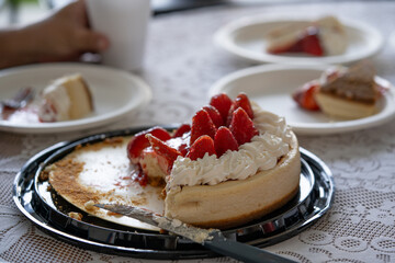 tarta o pay de limón con fresas recién servido a los invitados a cumpleaños en platos desechables