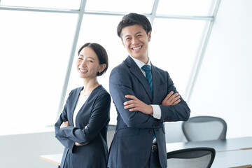 腕組みをする男女　ビジネスシーン