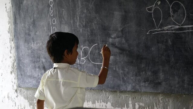 Asian school boy wearing uniform. Portrait of happy cute little indian boy in school uniform, Adorable elementary kid showing black board. child education concept. rural india.