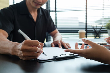 Cropped view of two professional businesspeople analyzing statistics data at office desk.