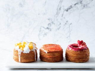 Assorted croissant donuts on a marble background