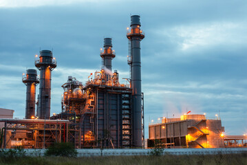 Oil refinery plant chemical factory and power plant with many storage tanks and pipelines at sunset.