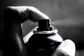 spray bottle in hand, a man's finger sprays perfume