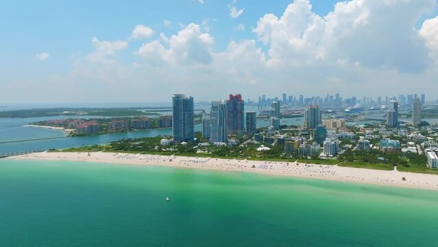 Aerial view of high private skyscrapers hotels locating near shore of crystal clean Atlantic Ocean. Background of Fisher Island and Miami Downtown