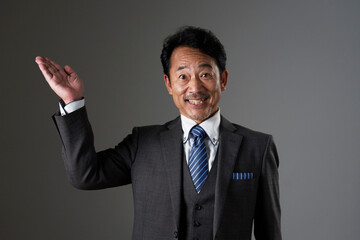 上方向を手の平で指す中年のビジネスマン　黒背景
