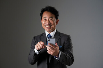 スマホを使う中年のビジネスマン　黒背景