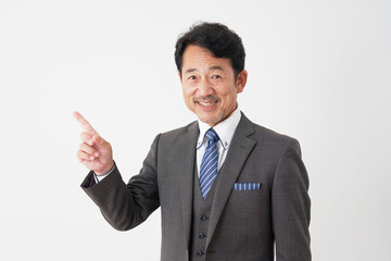 左側を指差す中年のビジネスマン　白背景