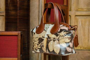 Display of leather bags for women made by craftsmen in Indonesia. Various types of detailed and beautiful women's bags are combined with eco print artwork with leaf and flower motifs