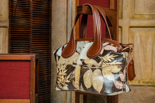 Display of leather bags for women made by craftsmen in Indonesia. Various types of detailed and beautiful women's bags are combined with eco print artwork with leaf and flower motifs