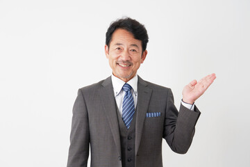 手の平で右側を指す中年のビジネスマン　白背景