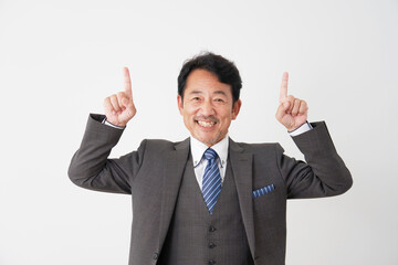 上方向を指差す中年のビジネスマン　白背景