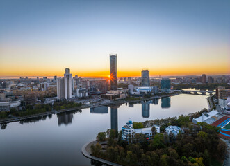 Fototapeta na wymiar Yekaterinburg city and pond aerial panoramic view at summer or early autumn sunset. Night city in the early autumn or summer.