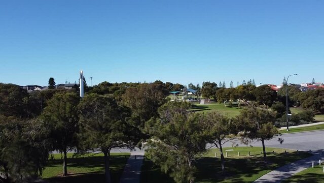 Aerial Reveal Shot Of Modern Lighthouse Glowing In Park, Mindarie - Perth