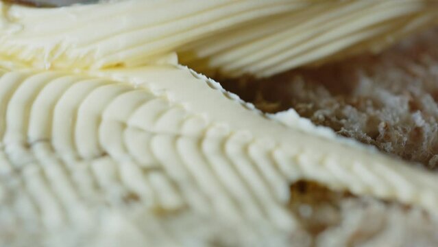 Beautiful Macro shot of margarine butter being spread on slice of bread with knife