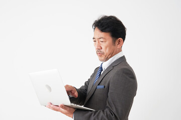 ノートパソコンを使う中年のビジネスマン　白背景