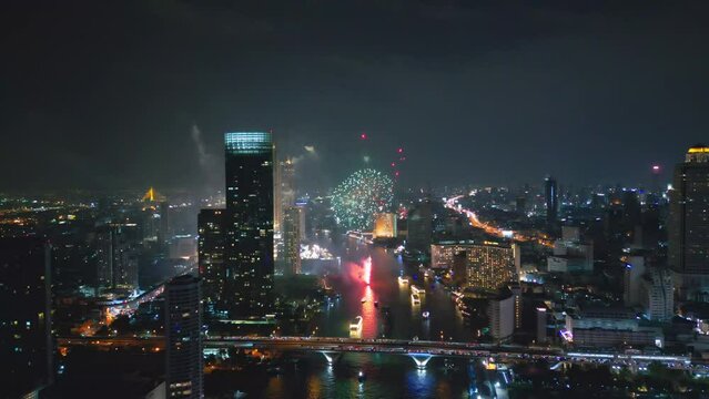 Aerial drone point of view Multi colors Fireworks Displays over the Cityscape and Skyscraper Celebrate Night Lights, river and Bangkok bridge
