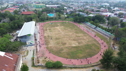 Aerial view of people running at the GOR Nani Wartabone, Gorontalo City. Group of people on the running track, the football field, or the soccer field. 