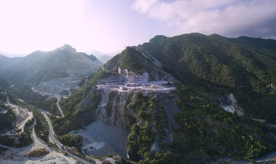 Aerial panorama of marble quarries Carrara Italy. Cumulus clouds over the mountain peaks of marble quarries. .Carrara Marble Quarry - Tuscany - Italy. Mountain peaks at sunrise.