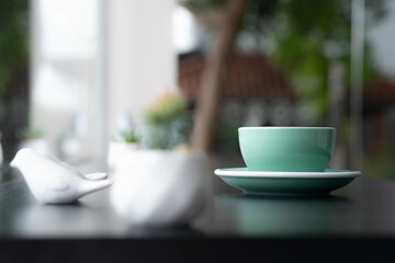 A Cup of Coffee on the table with  background of garden