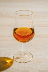 Tulip glass with cognac on wooden table