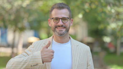 Outdoor Portrait of Middle Aged Man Doing Thumbs Up