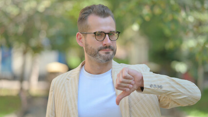 Outdoor Portrait of Middle Aged Man Doing Thumbs Down