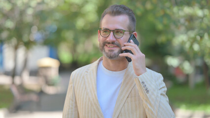 Middle Aged Man Talking on Phone Outdoor