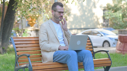 Fototapeta premium Modern Casual Man with Toothache Working on Laptop Outdoor