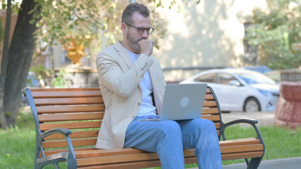 Fototapeta premium Coughing Modern Casual Man Using Laptop Outdoor